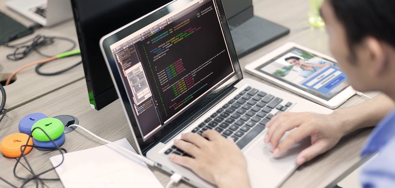 IT-Haftpflicht für beratende Ingenieure Ein Programmierer sitzt am PC und schreibt einen Code.